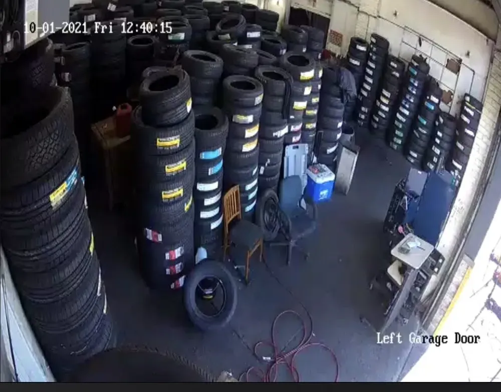 New tires with labels stacked in the garage, seen from a security camera