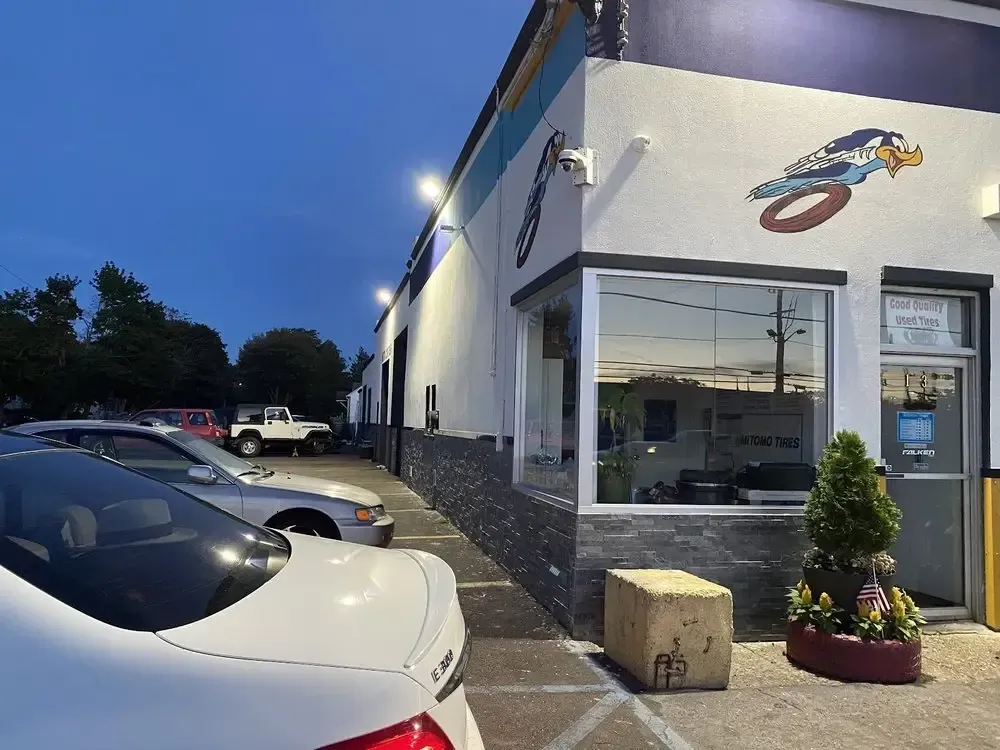 Corner office window and roadrunner mural of Christian’s Road Runner Tire Service in the evening
