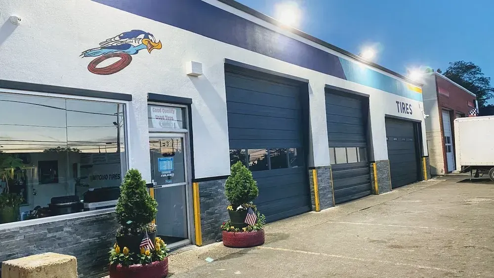 Front of Christian’s Road Runner Tire Service with its roadrunner mural, bay doors and Tires sign