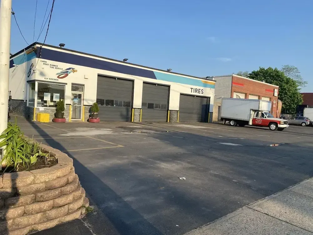 Christian’s Road Runner Tire Service building with three bay doors and its parking lot
