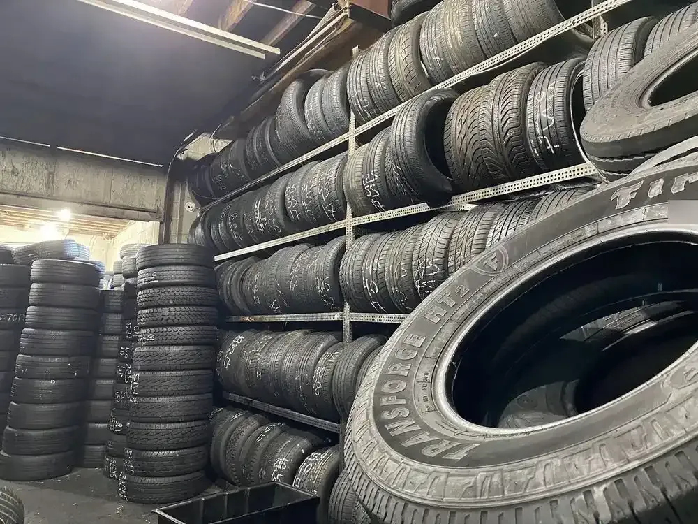 Rows of used tires on metal shelves inside the shop, one tire in front